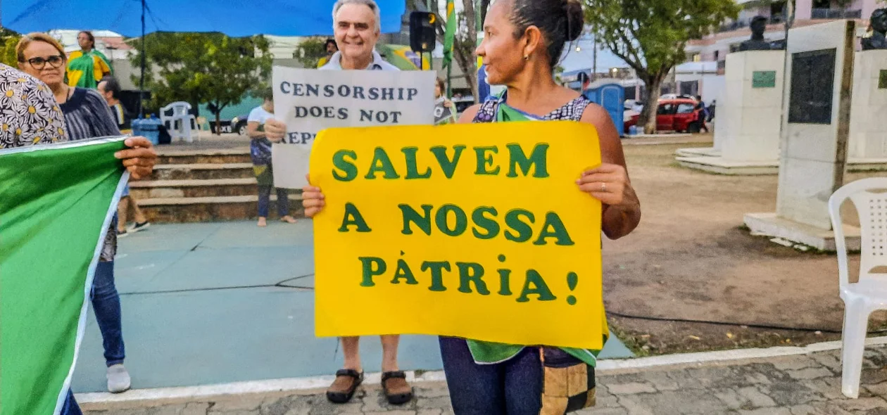 Manifestantes segurando cartazes