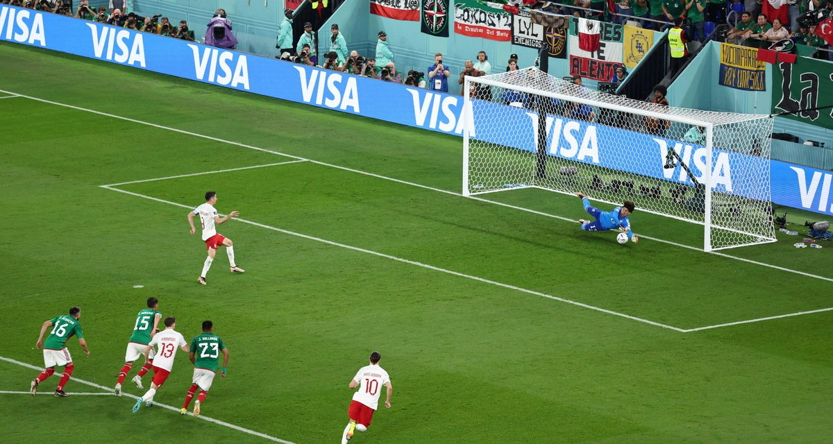 Momento da batida defendida por Ochoa, que aumentou o jejum de gols de Lewandoswki em Copas