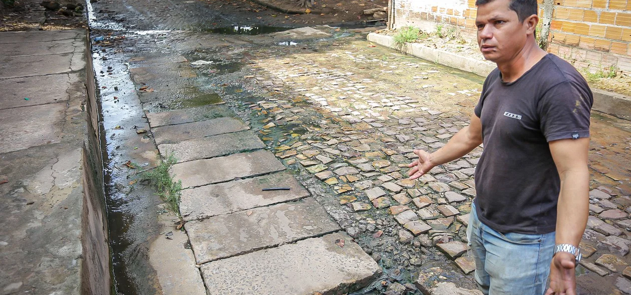 Edilson mostra água do esgoto do condomínio que está passando por cima da Rua Boa Esperança