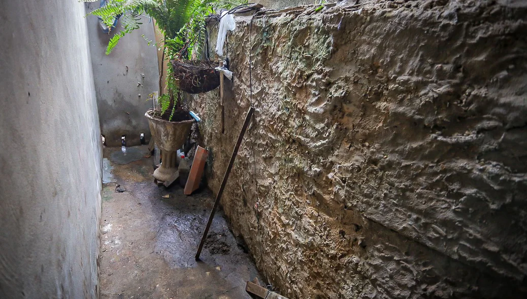Local por onde a água escorre do terreno do condomínio para a casa de Edilson