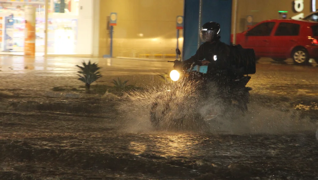 Motociclista enfrentando o trânsito na chuva