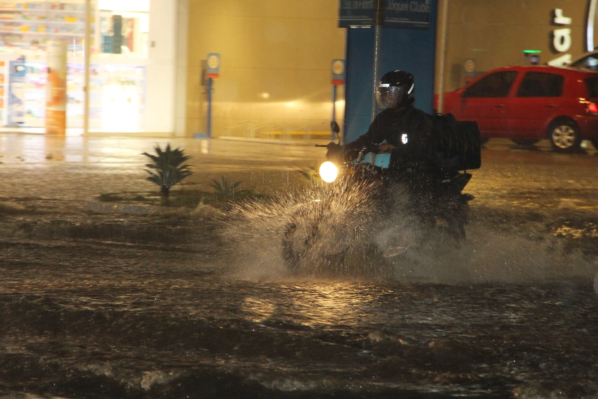 Motociclista enfrentando o trânsito na chuva