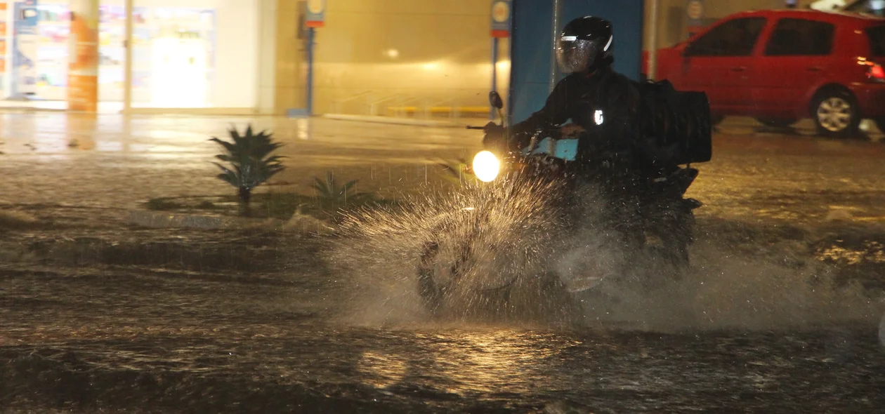 Motociclista enfrentando o trânsito na chuva