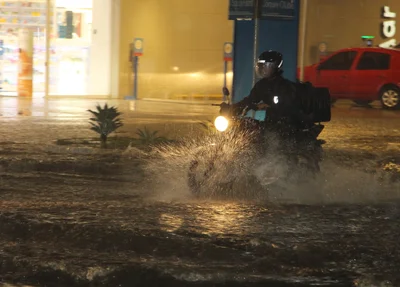 Motociclista enfrentando o trânsito na chuva