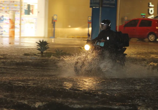Motociclista enfrentando o trânsito na chuva