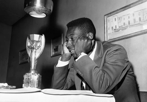 Pelé admirando a taça da Copa do Mundo de 1958