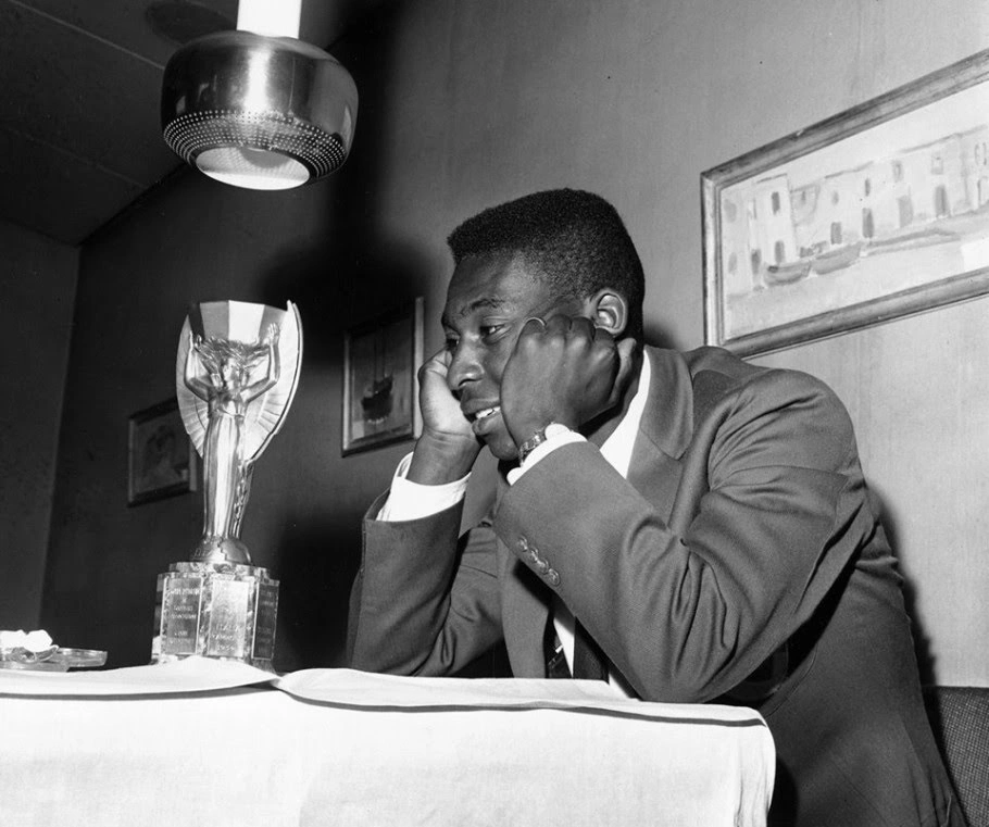 Pelé admirando a taça da Copa do Mundo de 1958