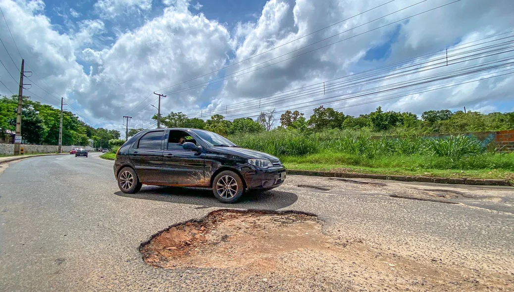 Carro muda de faixa para não cair no buraco
