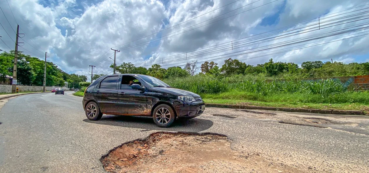 Carro muda de faixa para não cair no buraco