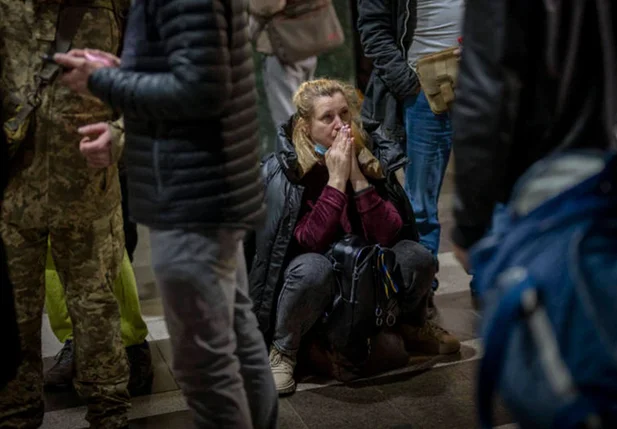 Mulher reage à situação na Ucrânia enquanto aguarda um trem partir, em Kiev, na Ucrânia