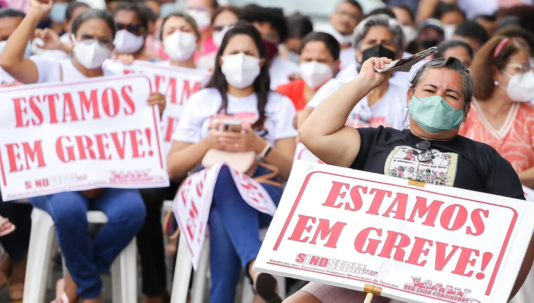 Professores com cartazes reivindicando melhorias salariais