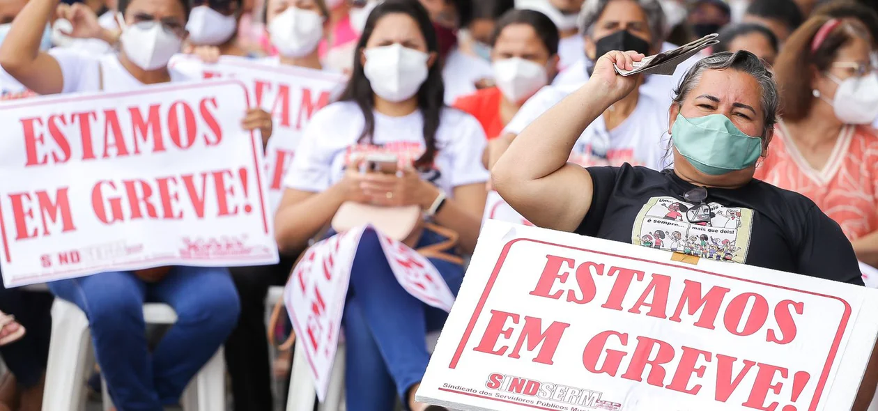 Professores com cartazes reivindicando melhorias salariais