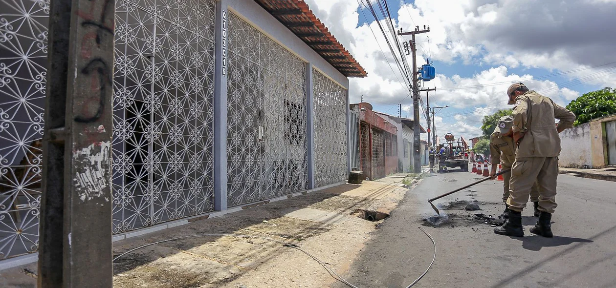 Equipe do Corpo de Bombeiros retirando o fio caído na frente da residência