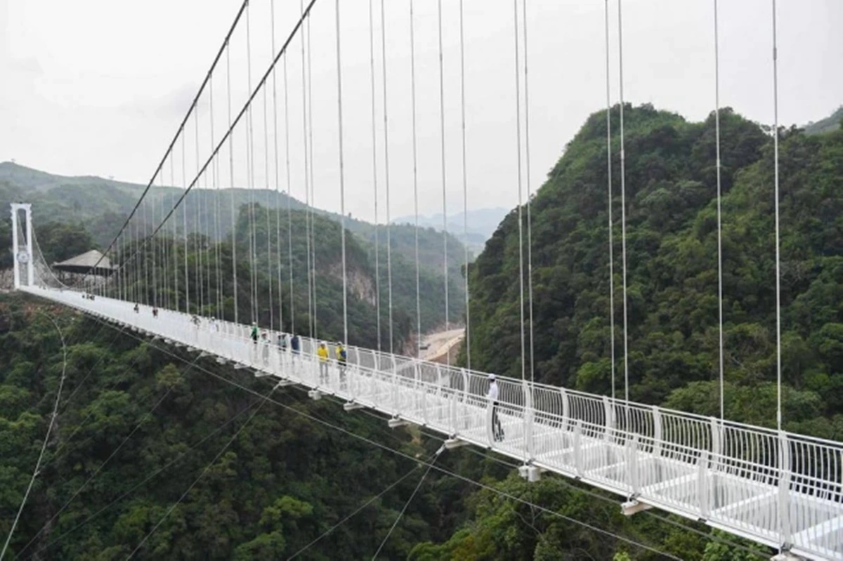 Visitantes caminham na ponte de vidro Bach Long, no distrito de Môc Châu, na província de Son La, no Vietnã