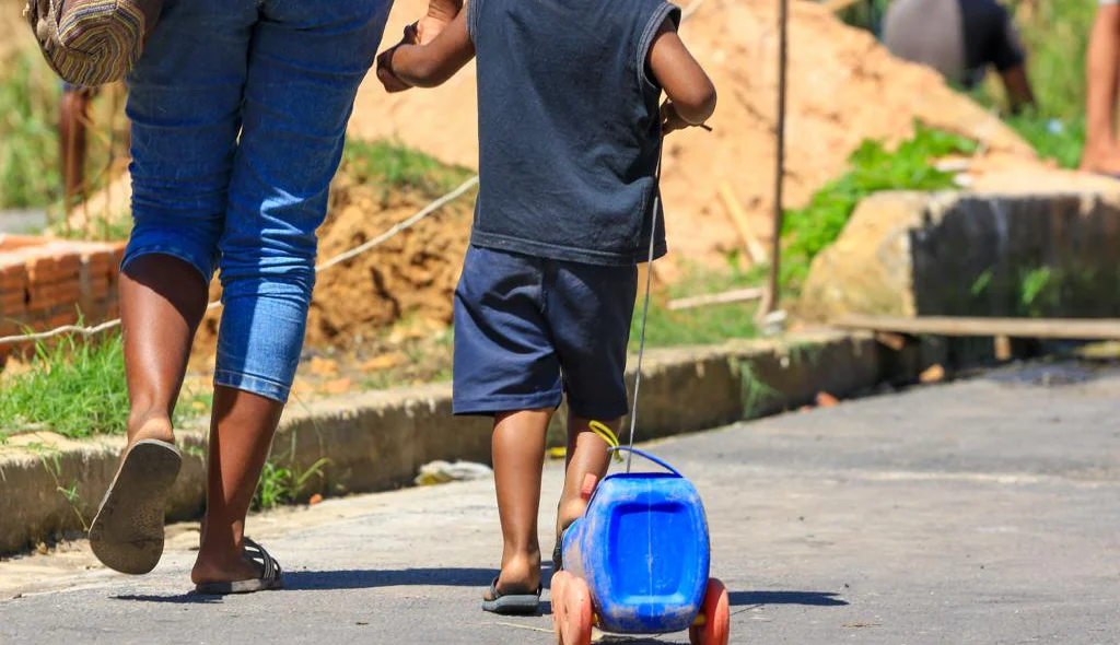 Criança saindo da reitegração de posse com seu carrinho