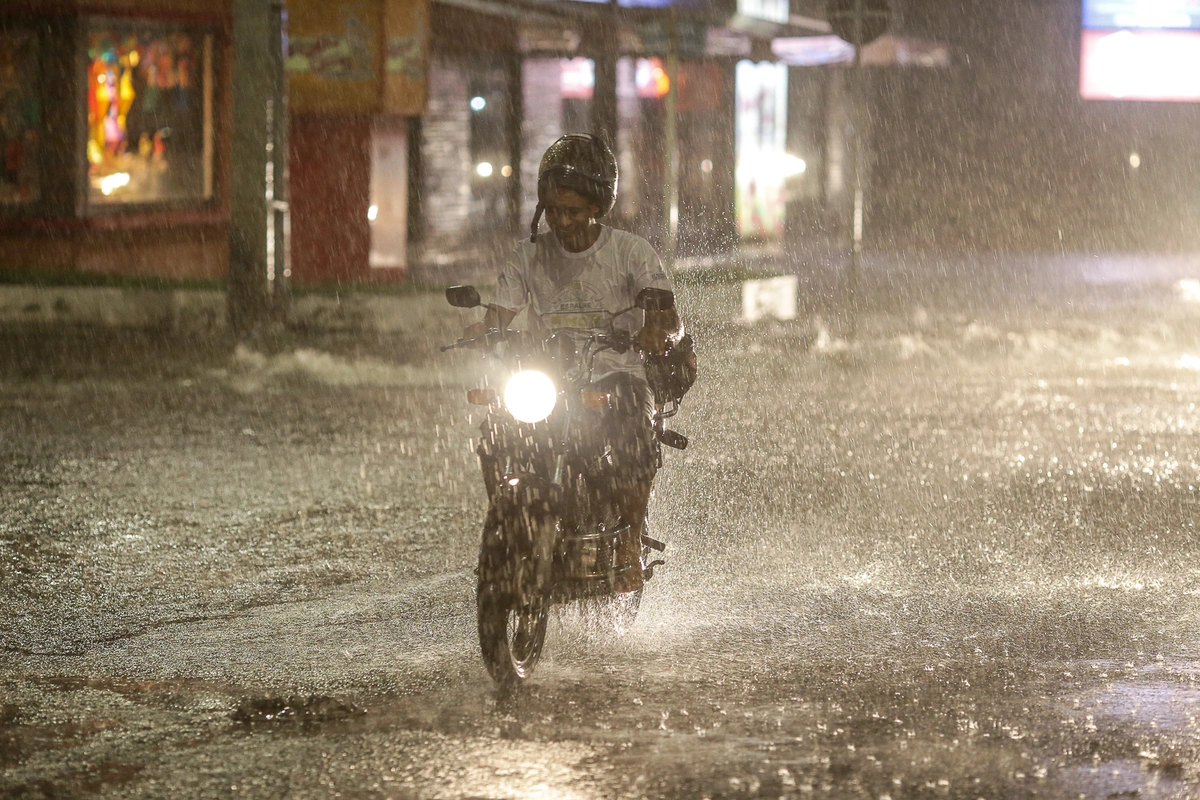 Motociclista se arriscando na chuva