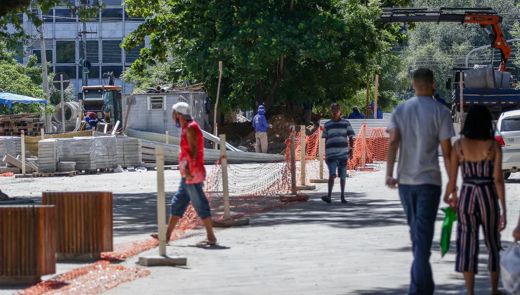 Pedestres passam pela obra