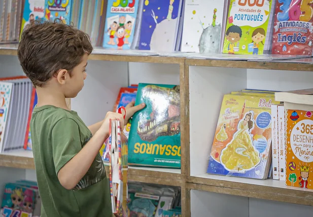 Criança escolhendo seu livro no Salipi