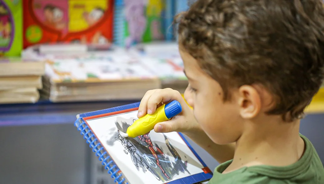 Criança pintando livro no Salipi