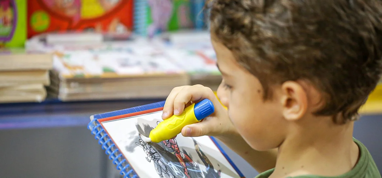 Criança pintando livro no Salipi