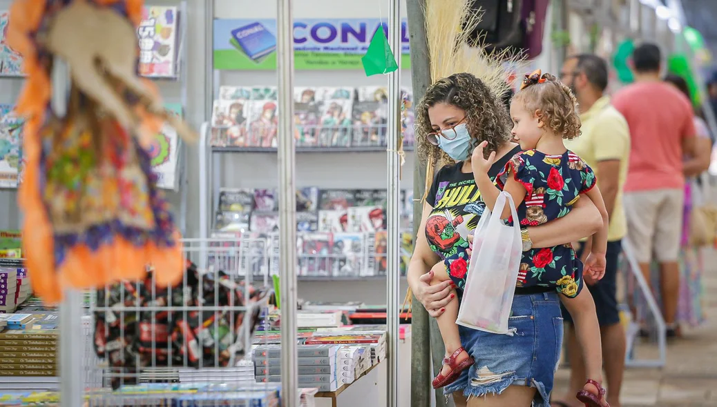 Mãe e filha observando os livros no Salipi