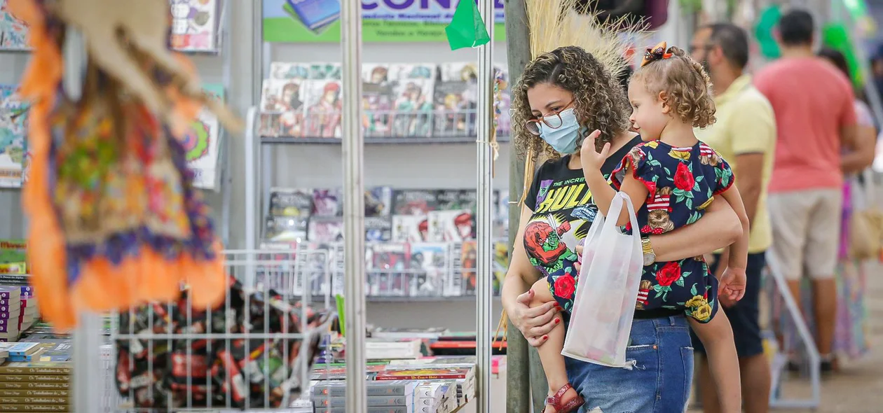 Mãe e filha observando os livros no Salipi