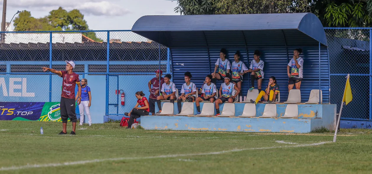 Treinador orienta equipe no banco de reservas