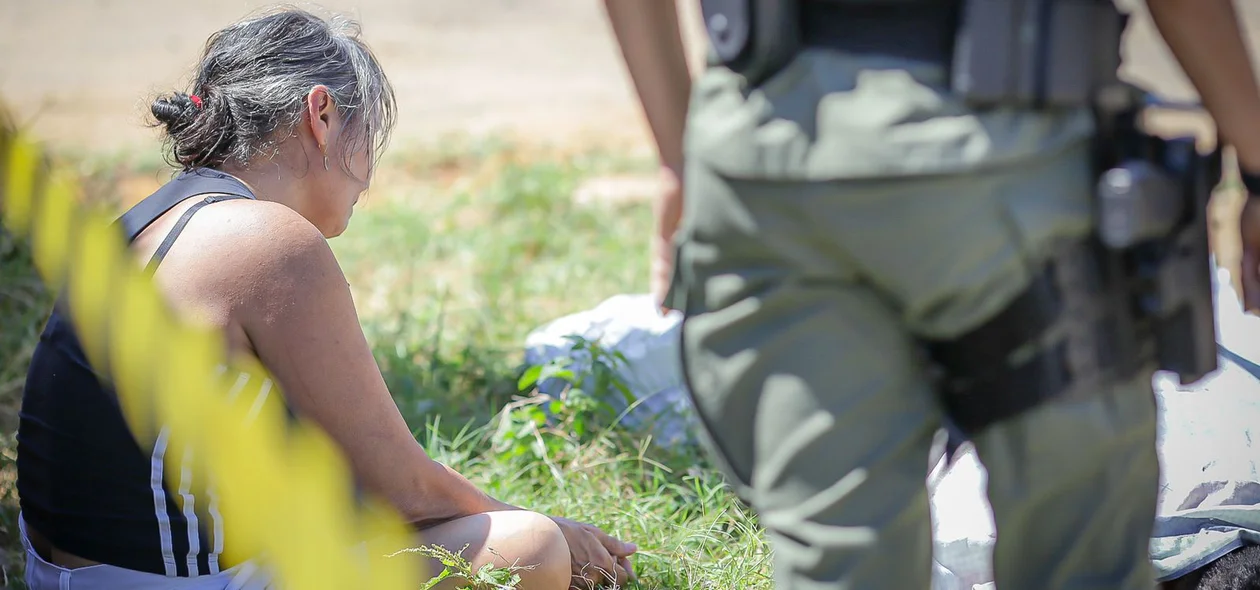A mãe do rapaz chorando próximo ao corpo do filho