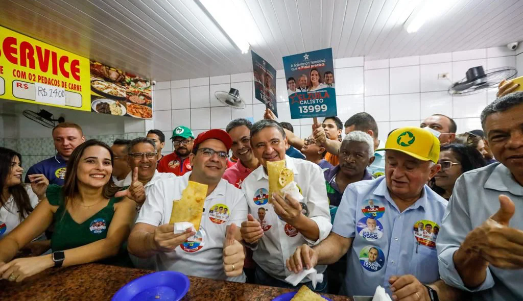 Wellington e Rafael comendo pastel com várias outras autoridades no centro de Teresina