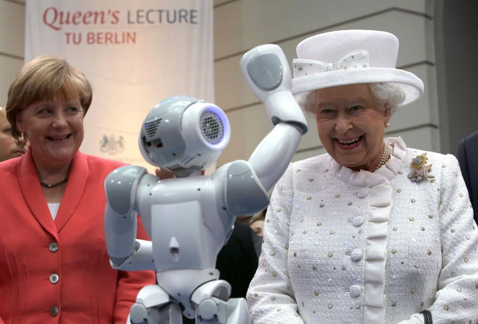 A chanceler alemã Angela Merkel e a rainha britânica Elizabeth II interagem com um robô durante uma recepção na Technische Universitaet em Berlim, Alemanha
