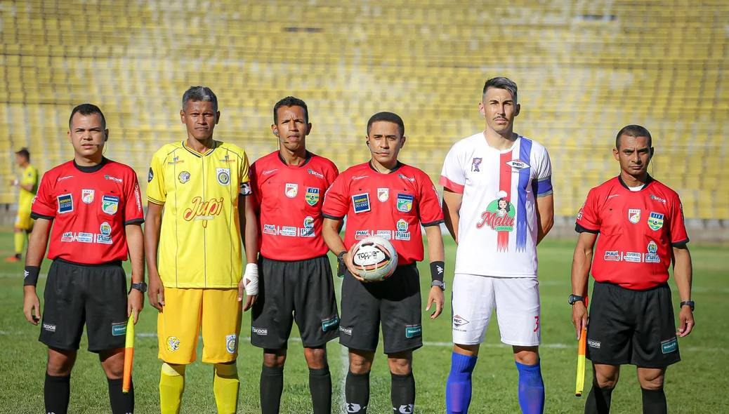 Equipe de arbitragem com os capitães de cada time