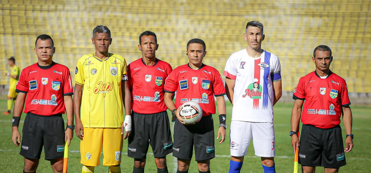 Equipe de arbitragem com os capitães de cada time