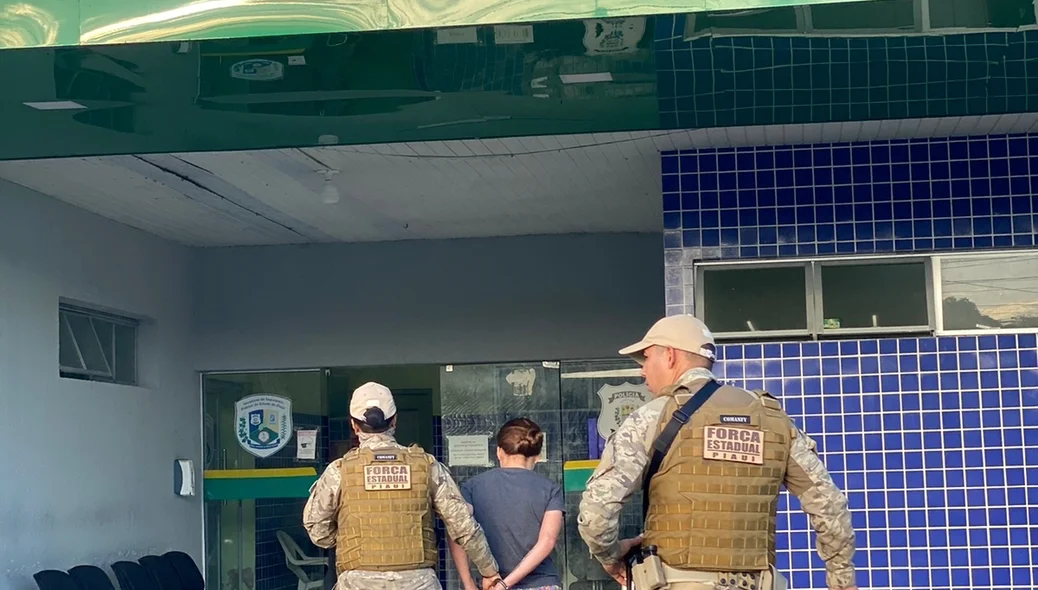 Mulher sendo conduzida para a central de flagrantes