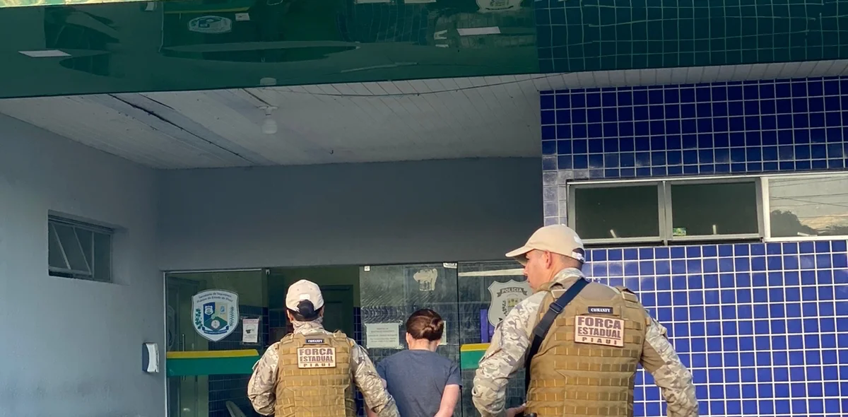 Mulher sendo conduzida para a central de flagrantes