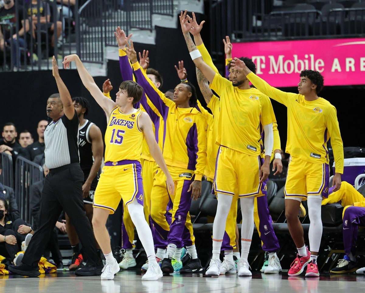 Austin Reaves chuta para 3 pontos em frente ao banco do Lakers