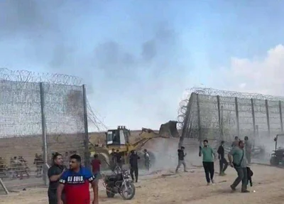 Palestinos usam retroescavadeira para retirar cerca