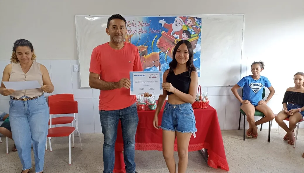 Aluna da rede municipal recebendo o certificado