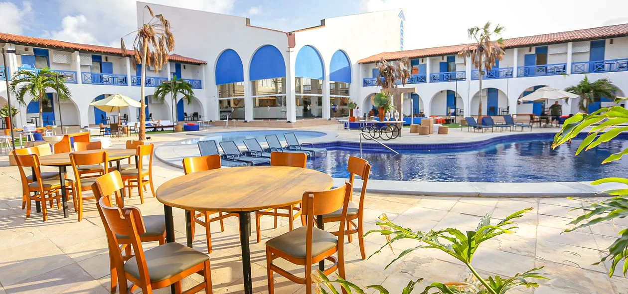 Espaço com mesas ao lado da piscina