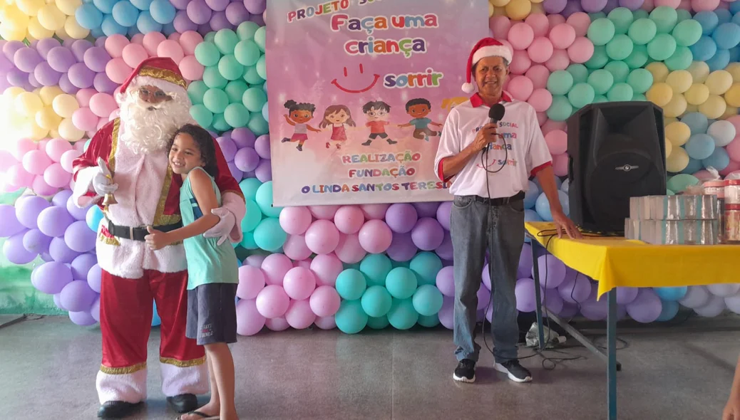 Irmão Gilvan, idealizador do projeto "Faça uma criança sorrir", ao lado Papai Noel, que entregava um presente