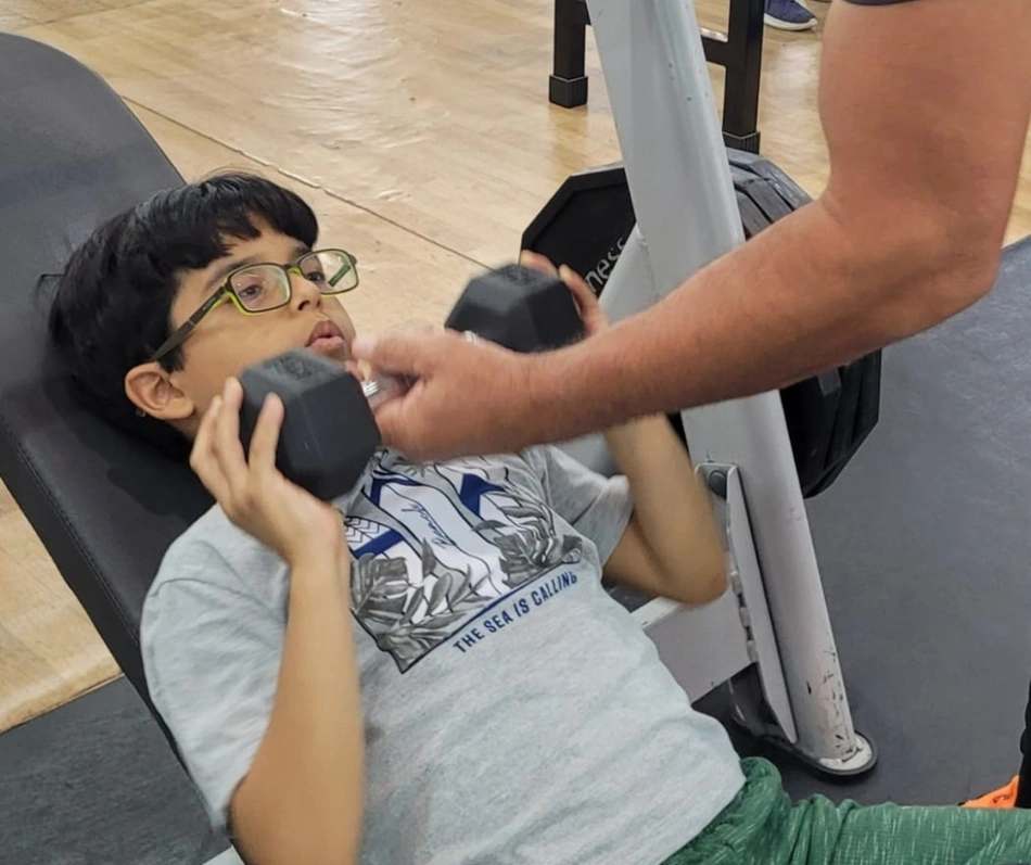 Vinícius Oliveira Muller de 8 anos fazendo musculação