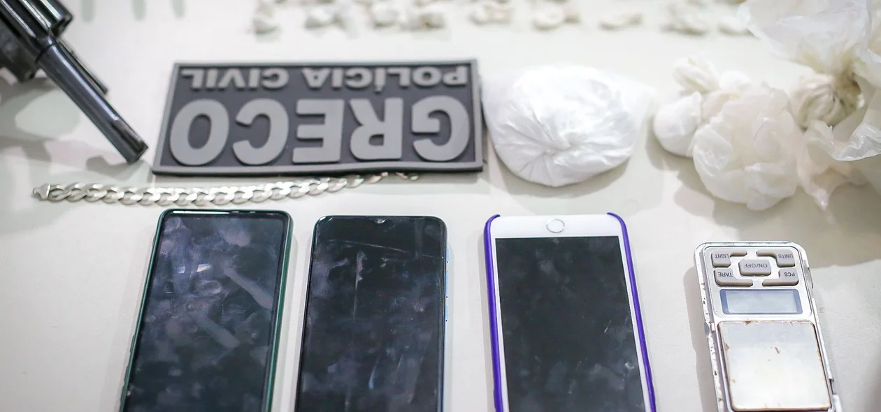 Celulares, arma e droga apreendida em poder dos criminosos