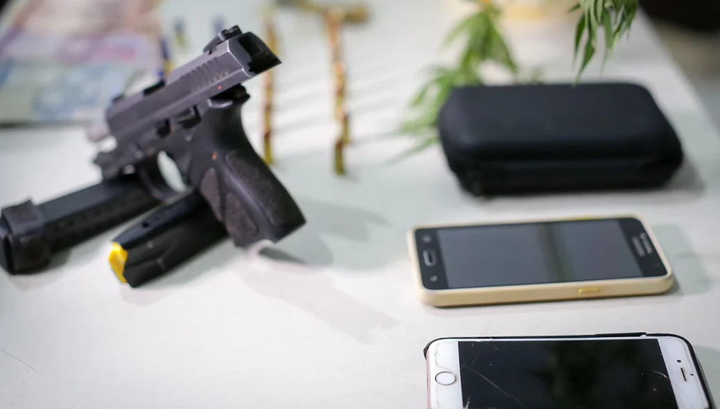 Celulares e arma apreendidos