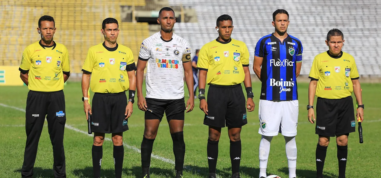 Equipe de arbitragem alinhada junto aos capitães dos times