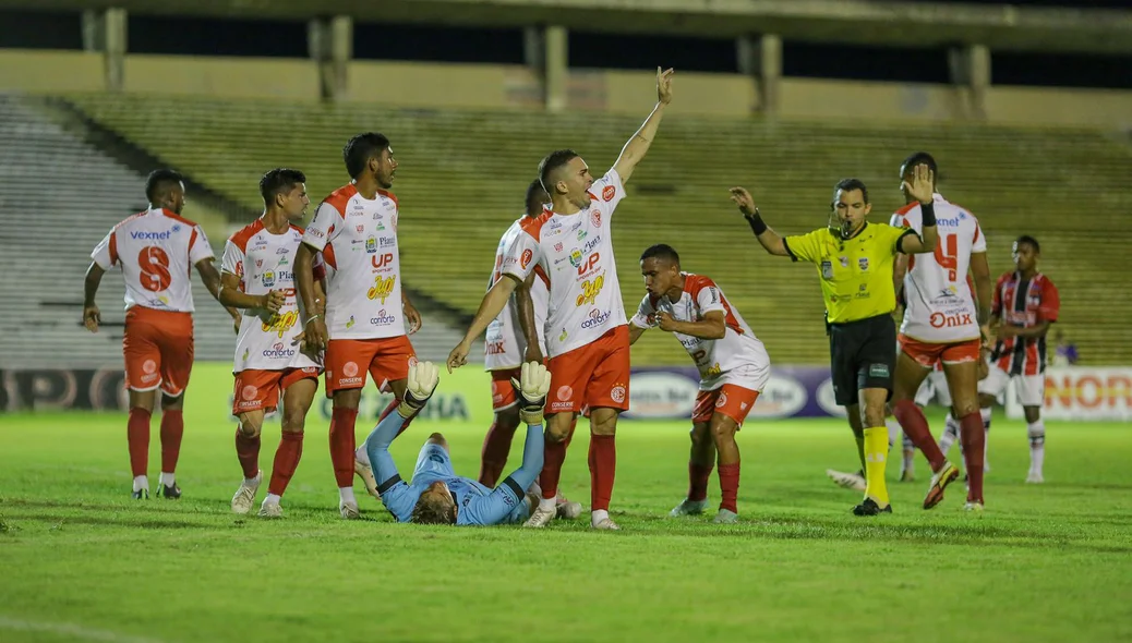 Goleiro Jailson no chão e jogadores do 4 de Julho pedindo atendimento