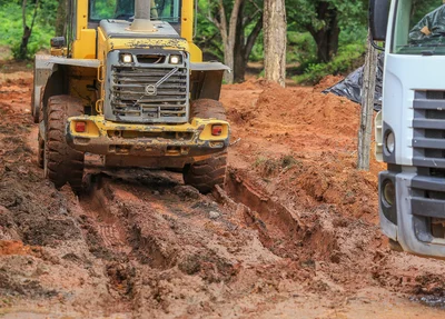 Trator espalha o entulho no local