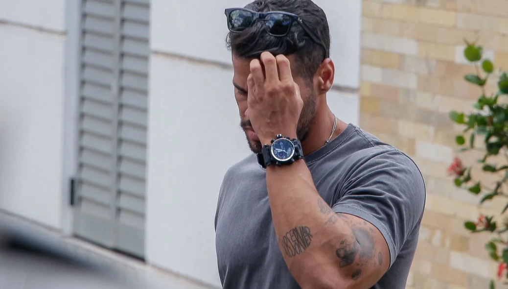 Christhofer Santos se dirigindo ao carro da polícia