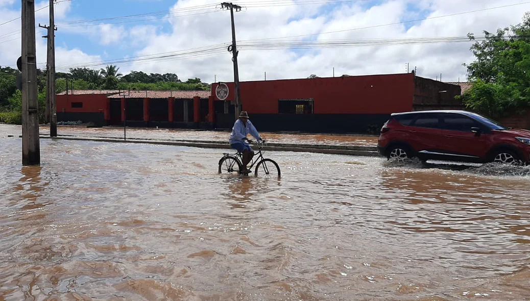 Condutores passam pelo local alagado