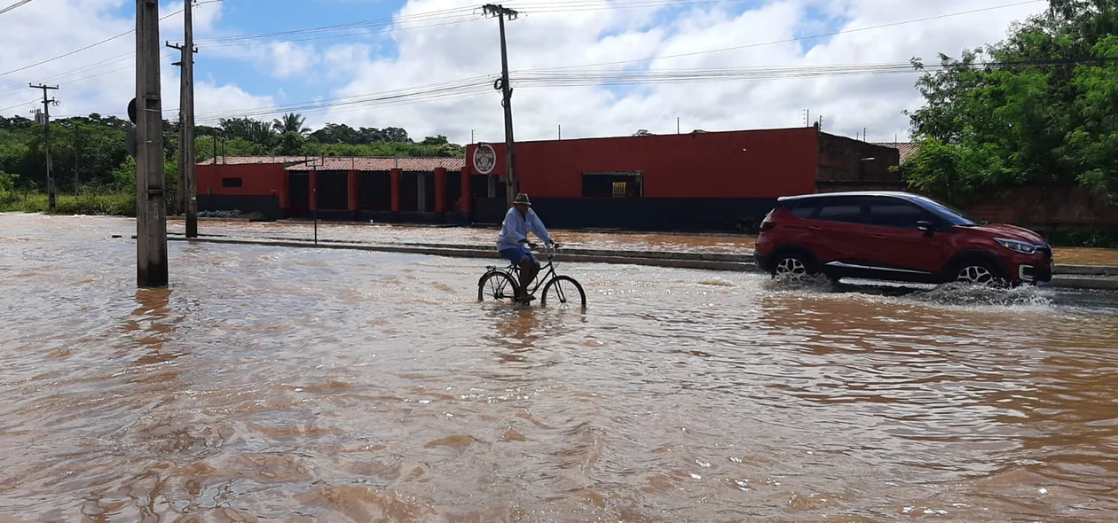 Condutores passam pelo local alagado
