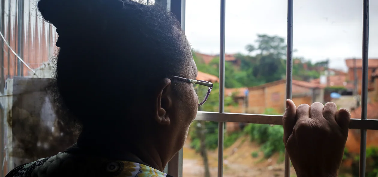 Dona Joana mostra visão para o grotão, da janela de casa
