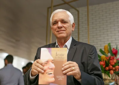 Themístocles Filho segurando um exemplar do livro